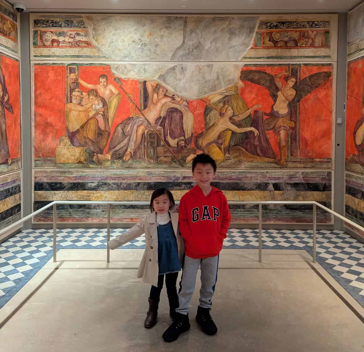 a boy and girl posing in a room with a mural Kelsey Museum of Archaeology in Ann Arbor