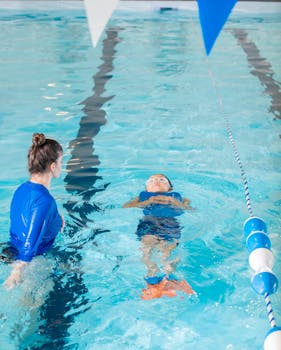 6 Practical Skills Parents Should Master for Their Michigan Home 1 A swimming instructor teaches a young child to swim in an indoor pool.