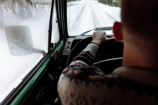 6 Practical Skills Parents Should Master for Their Michigan Home 2 Experience driving on a snowy road with a person in a cozy sweater enjoying the winter view.