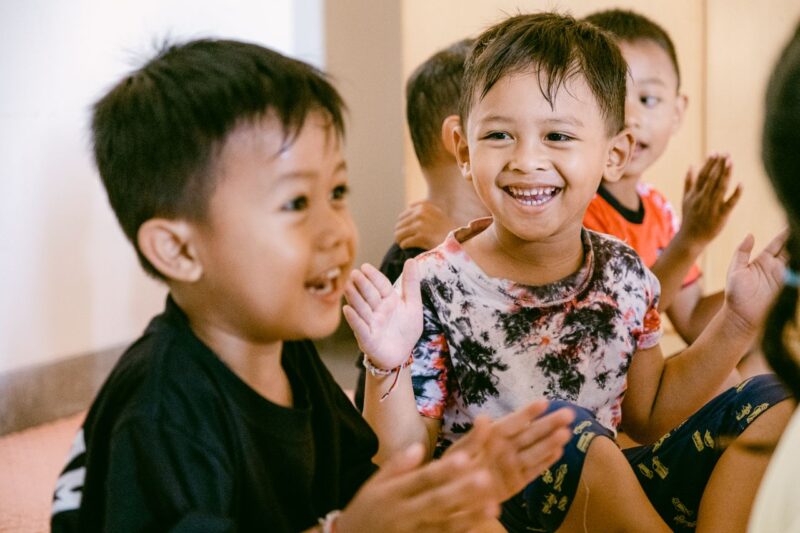 How Movement and Early Intervention Can Support Children With Dyslexia 2 Group of happy kids clapping and enjoying playtime indoors.